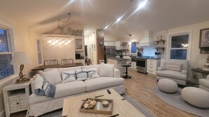 Un salon confortable avec un canapé, une table basse et un coin cuisine équipé d’une cuisinière et d’un réfrigérateur.