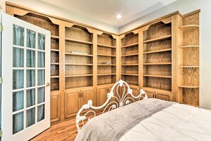 A bedroom with a bed, wooden wardrobe, and built-in shelving. - Walk to Lake: Middlefield Home w/ Fire Pit (Middlefield)