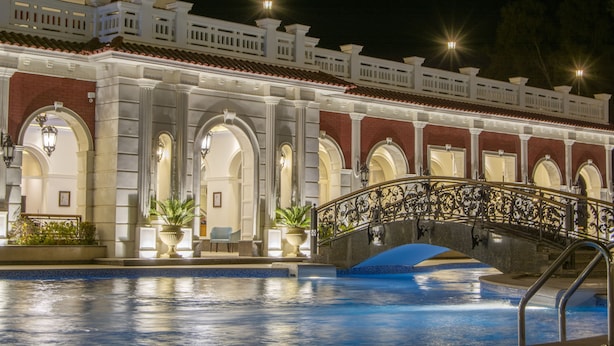 Un hôtel doté d’une piscine, d’un pont et d’une façade bien éclairée.