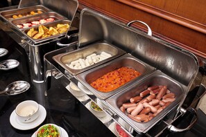 A buffet with various food options including sausages, potatoes, and other dishes. - The Palace Hotel - Adults Only (Alexandria)