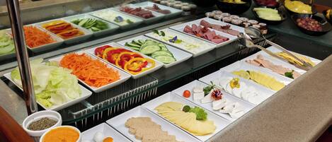 A buffet with various food items and condiments.
