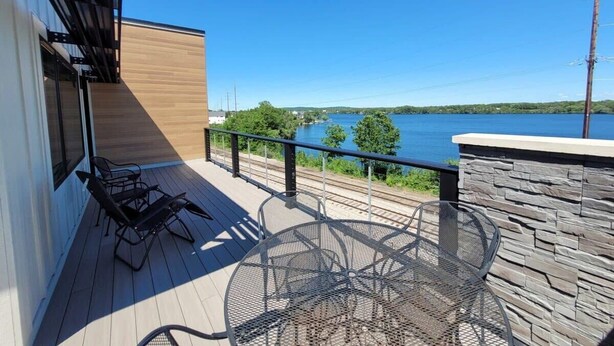 Un balcone con vista su un lago, un tavolo e due sedie.