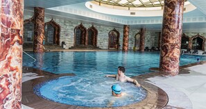 An indoor swimming pool with marble columns and a hot tub area. - Sarot Thermal Palace Tatil Koyu - Halal Hotel (Mudurnu)