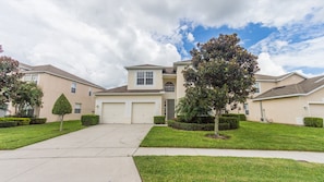 Homes in a quiet neighborhood with two-story structures, each featuring a garage and well-manicured lawns.