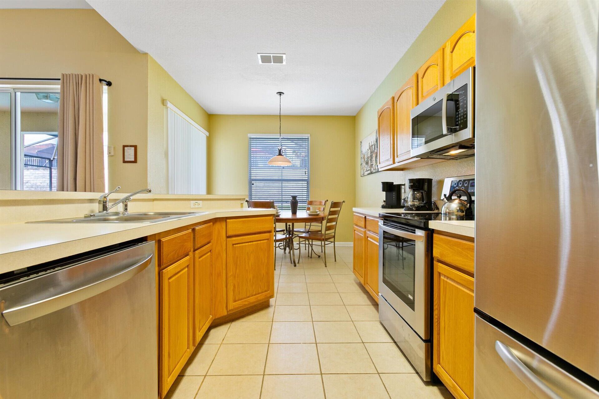 A modern kitchen with wooden cabinets, stainless steel appliances, and a central island.