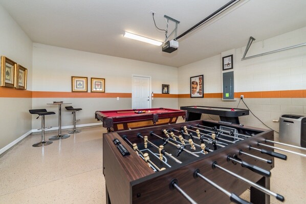 A room with a foosball table, pool table, and two bar stools. - Last Minute Disney! Private Pool, Hot Tub, Game Room & Themed Bedrooms. Book Now! #15098 (Orlando)