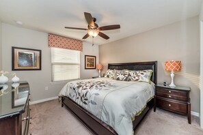A bedroom with a bed, a ceiling fan, a nightstand, and a dresser. - Last Minute Disney! Private Pool, Hot Tub, Game Room & Themed Bedrooms. Book Now! #15098 (Orlando)
