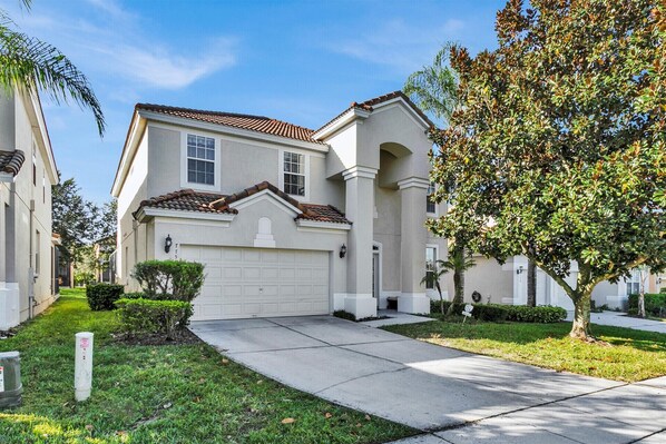 A residential house with a garage, a driveway, and a well-maintained lawn.