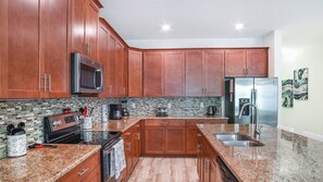 Enjoy cooking in this well-equipped kitchen with a microwave, oven, refrigerator, coffee maker, and toaster.