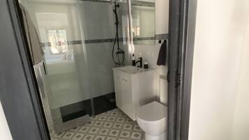 Un baño con ducha, inodoro y lavabo.