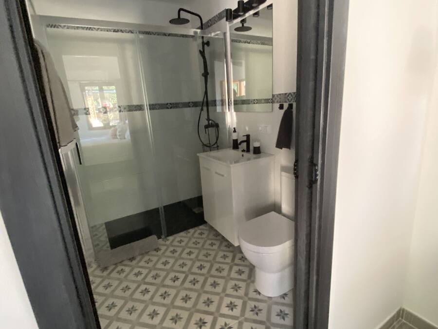 Un baño con ducha, inodoro y lavabo.