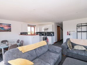 A compact living space with a kitchenette, a dining area, and a sofa. - Delphine Lodge, Meadow View Lodges (Burnham-on-Sea)