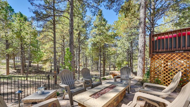 An outdoor patio with a stone fire pit, wooden chairs, and a table. - Flagstaff Hideaway: Private Hot Tub, 4 Mi to Dtwn! (Flagstaff)