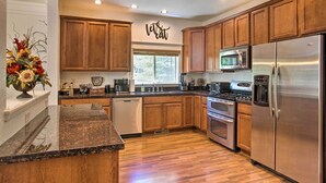 A modern kitchen with wooden cabinets, stainless steel appliances, and a granite countertop. - Flagstaff Hideaway: Private Hot Tub, 4 Mi to Dtwn! (Flagstaff)