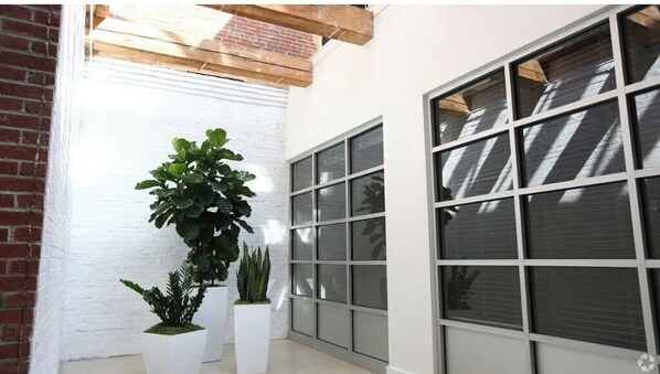 Experience a serene space with large windows and a brick accent wall.