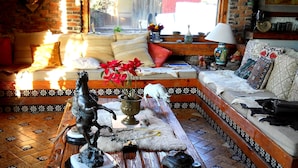 Un salón acogedor con una mesa de centro de madera, un sofá y una estatua decorativa de un caballo.