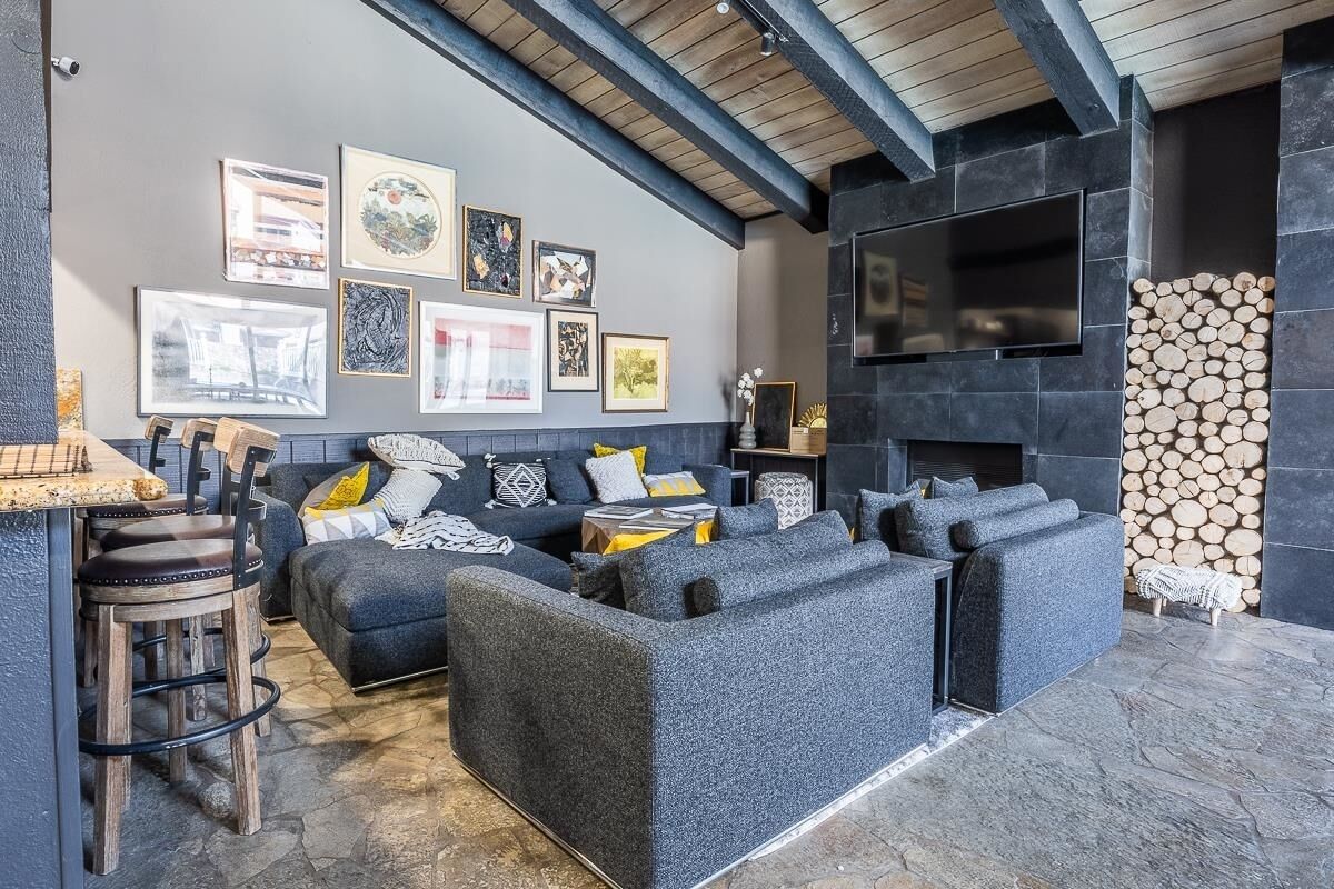 A modern living room with a sectional sofa, a fireplace, and artwork on the wall.