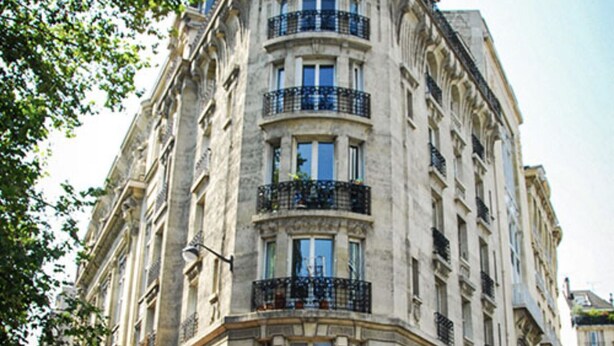 Un bâtiment historique abritant un café appelé « LE RAGPAIL » au rez-de-chaussée.