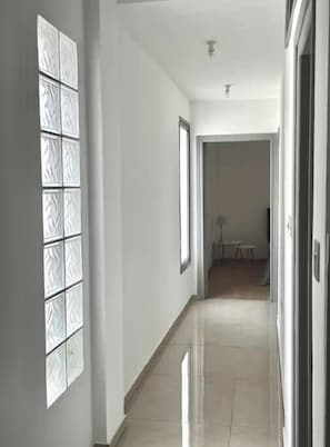 Stunning corridor with a collection of framed artworks leading to a doorway.