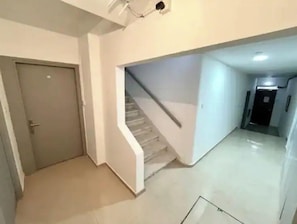 Staircase leads to a corridor with a door and a carpeted landing.