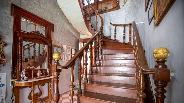 A wooden staircase with ornate balusters and a checkered floor. - Ayvalık Bonjour Pansiyon (Ayvalik)