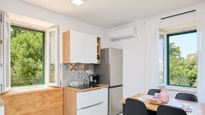 A modern kitchen with a wooden countertop, a built-in refrigerator, and a dining area with a table and chairs. - Apartment Fragola (Dubrovnik)