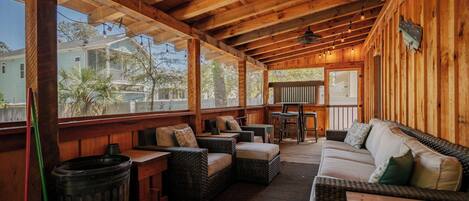 Relax in a comfortable outdoor seating area with wicker sofas and chairs, perfect for casual dining and taking in the neighborhood views.