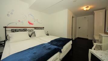Ein Schlafzimmer mit einem Bett, einem Nachttisch, einer Kommode und einer Wand mit einem dekorativen Bild.