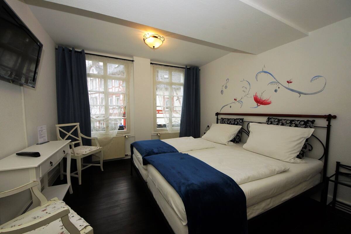 A bedroom with a single bed, a desk, and a chair.