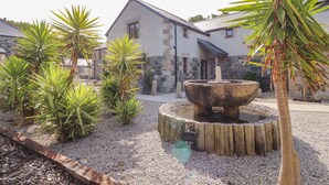 A stone building with a stone facade and a sloped roof. - Polurrian House (Helston)