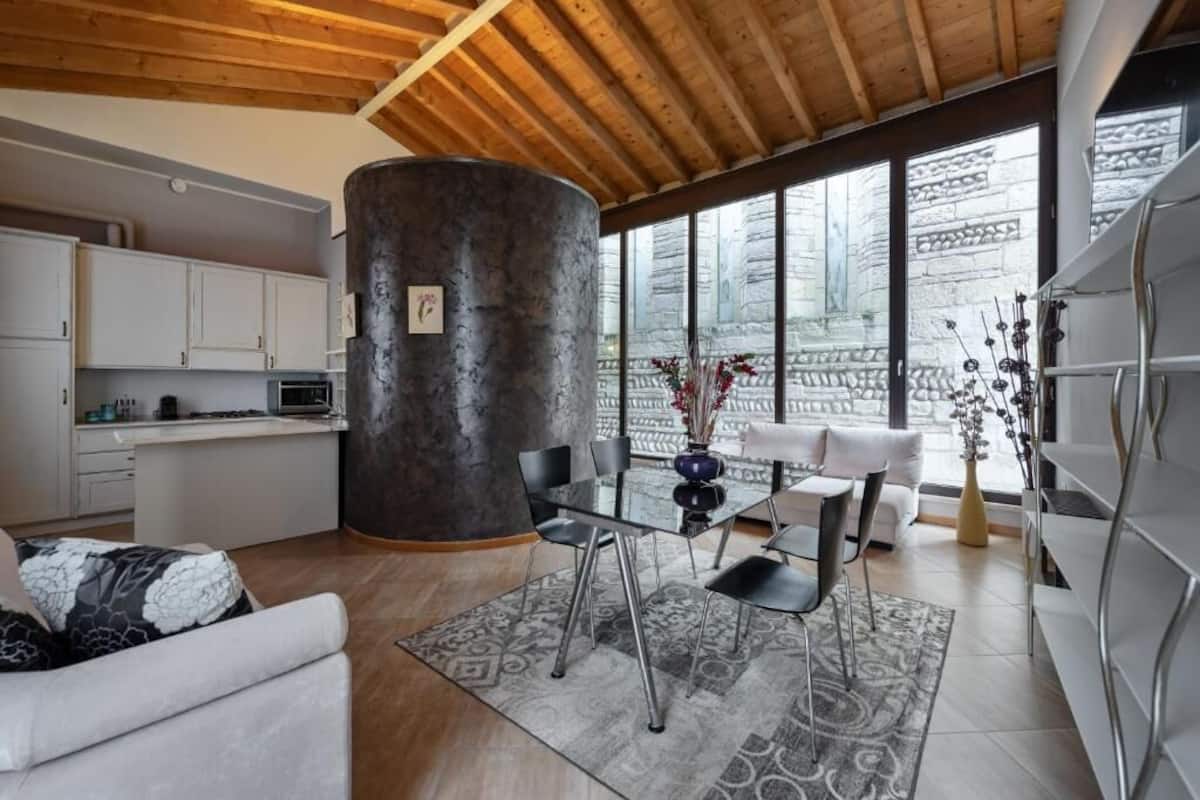 A modern interior with a dining area, kitchen, and seating space.