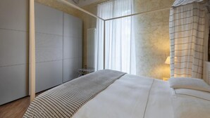 A bedroom with a bed, a wardrobe, and a window with curtains. - San Lorenzo (Verona)