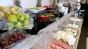 A buffet with various food items including fruits, vegetables, and meats. - BM HOTEL CITY (Samsun)