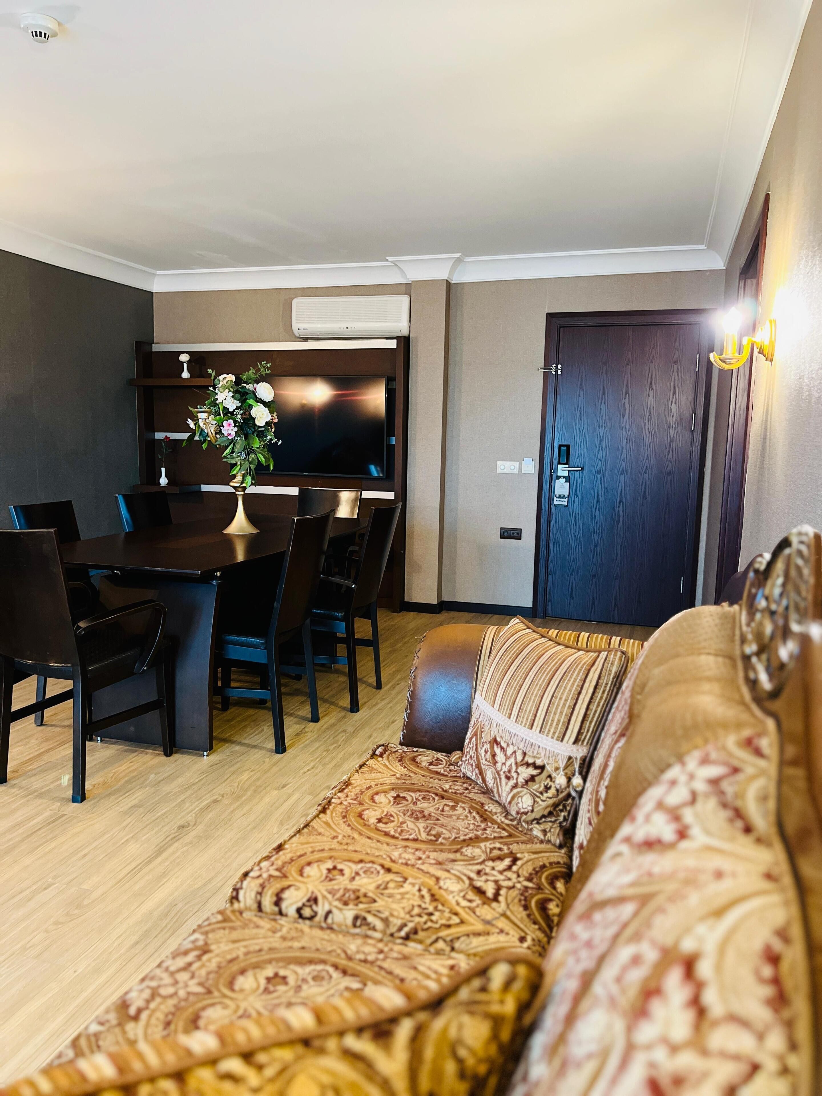 Una sala moderna con un sofá, una mesa de comedor con sillas y un televisor.