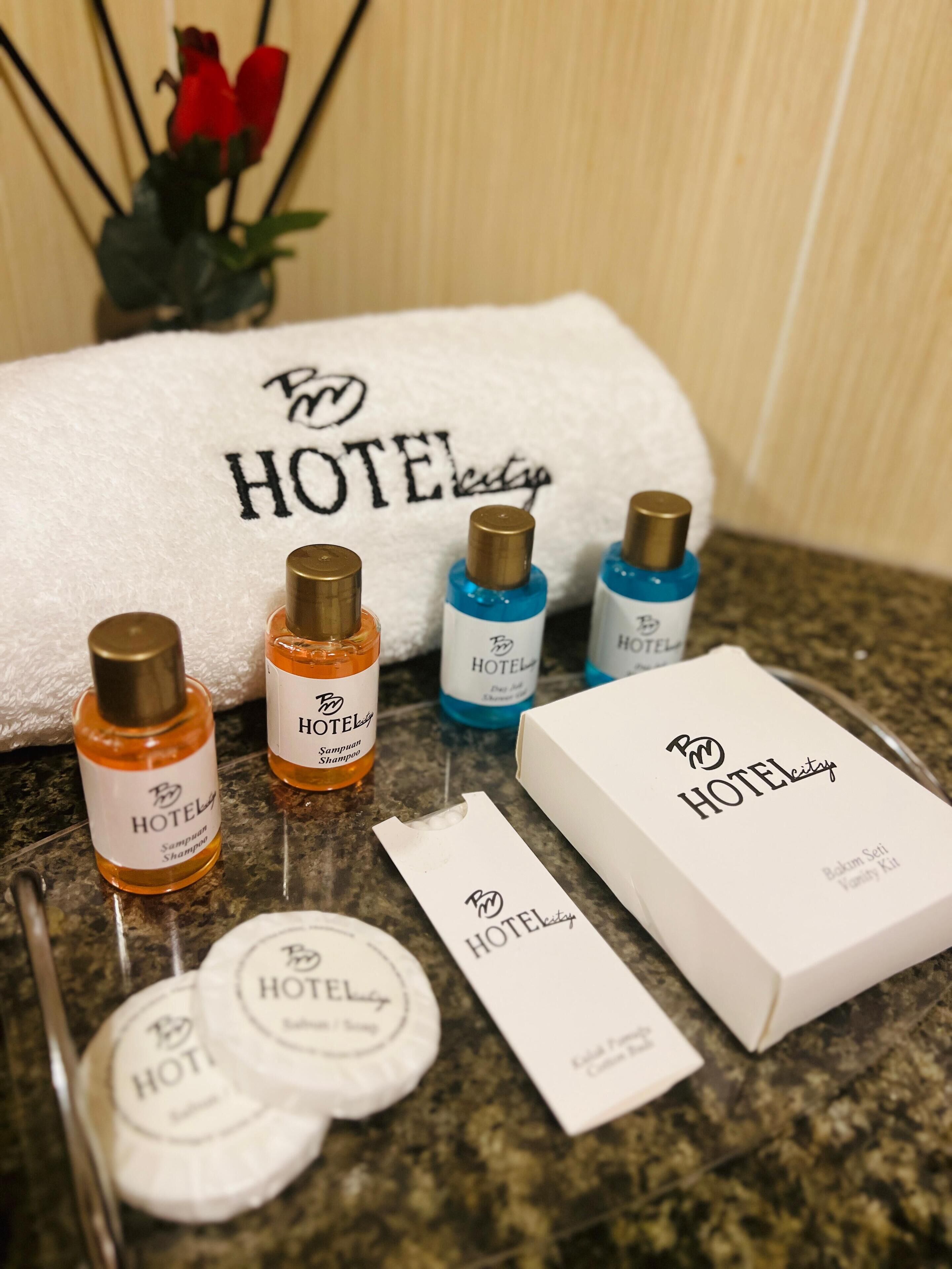 Et badeværelse på et hotel med toiletartikler, herunder shampoo, balsam og en tandbørste.