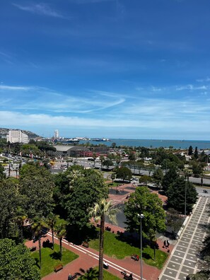 A cityscape with a park, a road, and a body of water in the background. - BM HOTEL CITY (Samsun)
