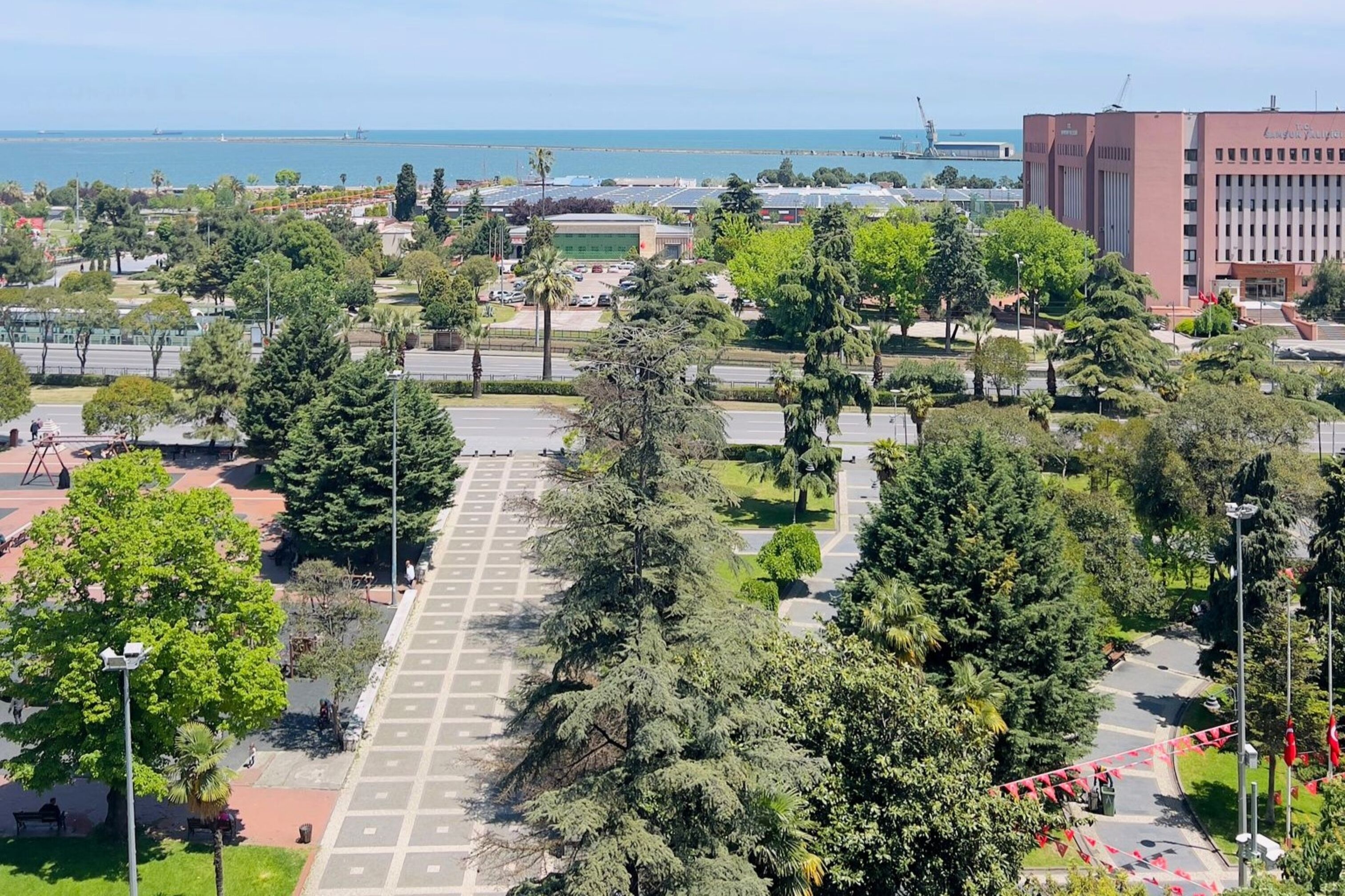 Un vaste parc public doté d’un espace central ouvert, entouré d’arbres et de sentiers.