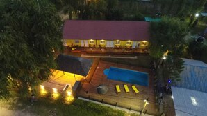 Ein Hotel mit rotem Dach, Schwimmbad und Außenbereich.