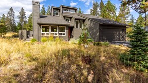 A modern two-story house with a garage, surrounded by tall trees and a grassy yard. - YANK01 - Cozy Home, Gas Fireplace, Dog Friendly (Sunriver)