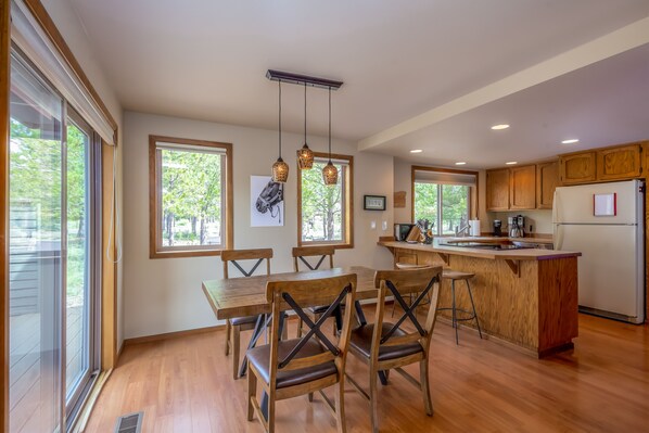 A modern kitchen with wooden cabinets, a central island, and pendant lighting. - YANK01 - Cozy Home, Gas Fireplace, Dog Friendly (Sunriver)