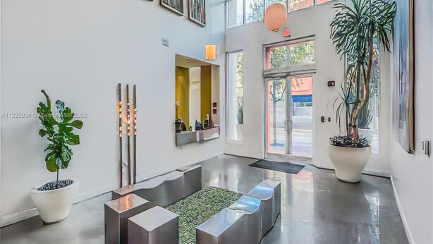 A modern lobby with a central seating area, large windows, and potted plants. - Fully Equipped Modern Loft in the Heart of Miami (Miami)
