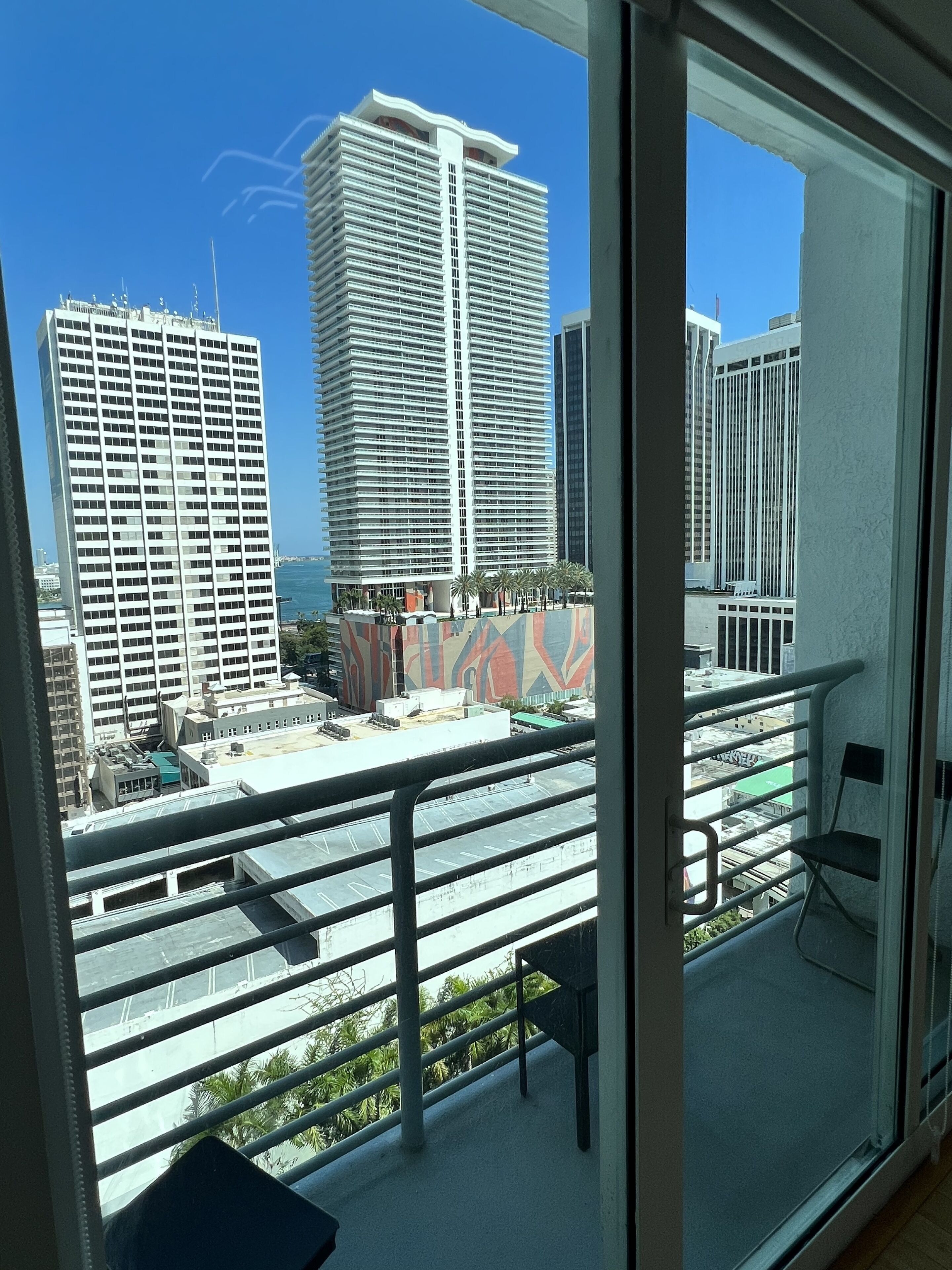 A balcony with a view of high-rise buildings and a clear sky.