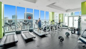 A gym with treadmills, weights, and exercise equipment, large windows with a city view. - Fully Equipped Modern Loft in the Heart of Miami (Miami)
