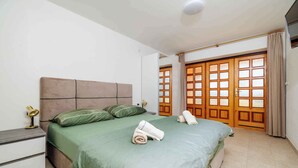 A neatly made bed with green bedding, a bedside lamp, and rolled towels. - Holiday apartment with 4 bedrooms and a balcony (Crikvenica)