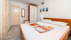 A hotel room with a bed, a wardrobe, a mirror, and a nightstand. - 100 metres to the beach (Baska)