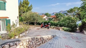 A paved driveway leading to a building with a tiled roof and green shutters. - 100 metres to the beach (Baska)