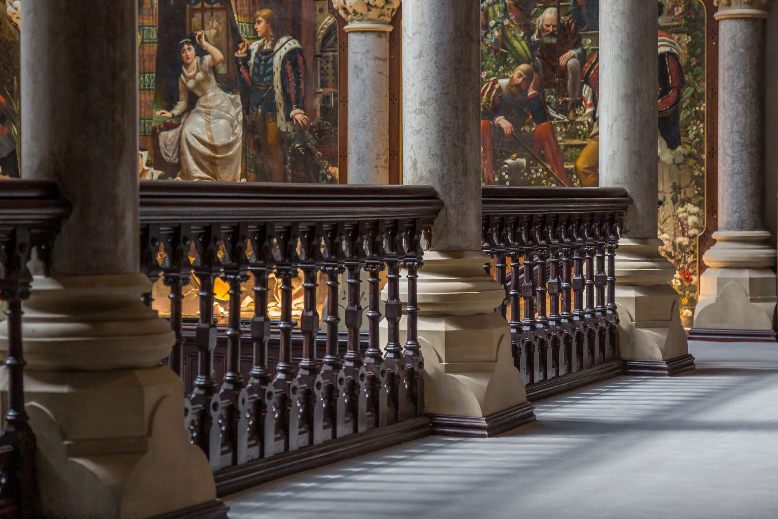 Un salón imponente con columnas ornamentales y un estilo arquitectónico clásico.