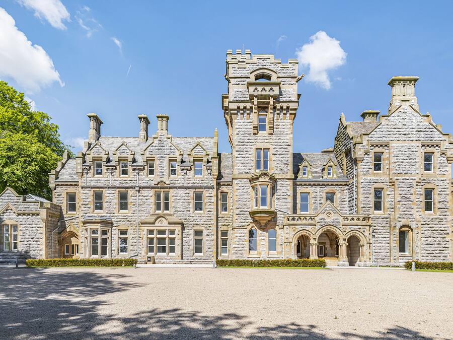 A large stone building with multiple towers and arched windows.