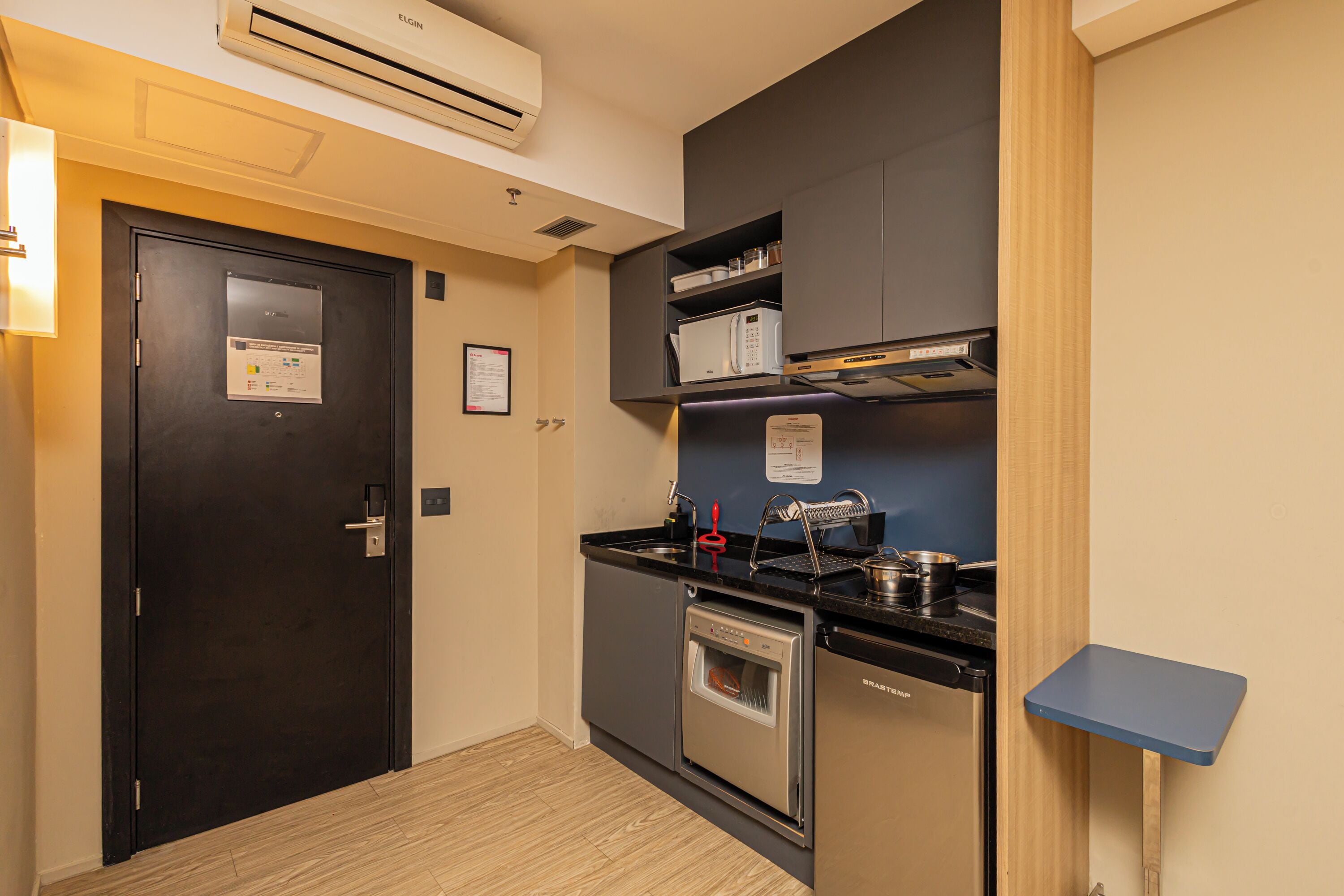 A compact kitchen with a dishwasher, oven, microwave, and a small countertop.