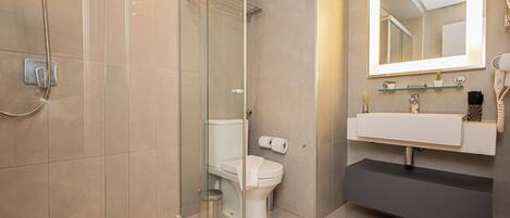 Un bagno moderno con doccia vetro, wc e lavabo con specchio.